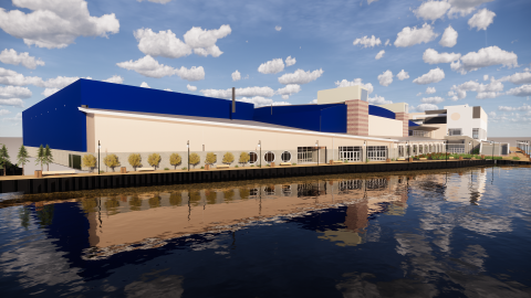 Exterior view of the new 45,000 square foot glass-front expansion of the Roland E. Powell Convention Center. The modern addition features multiple levels, large blue walls reaching three stories, and a windowed facade along the Assawoman Bay.