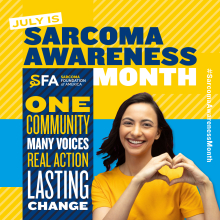 A person smiles while forming a heart shape with their hands. The background features text about July being Sarcoma Awareness Month, mentioning the Sarcoma Foundation of America. Bold words state: "One Community, Many Voices, Real Action, Lasting Change." On the side, the hashtag #SarcomaAwarenessMonth is displayed.